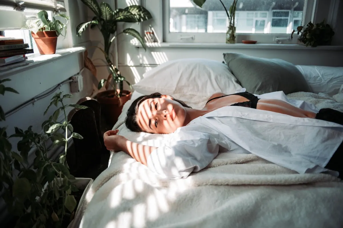 Lugn kvinna sover i ett mörkt sovrum, sömn är den viktigaste faktorn för att sänka kortisol